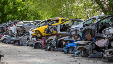 Car part salvage yard with rows of stacked wrecked cars