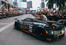 Crowds on either side of street watching Hard Rock supercar at Gumball 3000 event