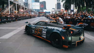Crowds on either side of street watching Hard Rock supercar at Gumball 3000 event