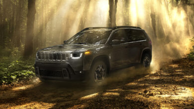 Blue Jeep Cherokee driving on rocky road