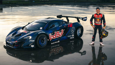 Mad Mike Whiddett standing next to Madmac Mclaren P1 GRR-X in wet parking lot