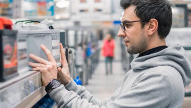 Man in shop looking at car batteries on a shelf copy