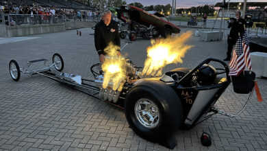 Person watching hot rod with flames shooting out