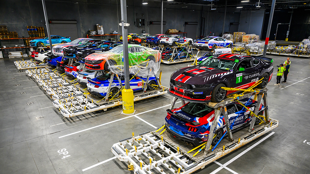 Racing cars in warehouse ready for transport to 2025 Mustang Challenge Dark Horse R Le Mans