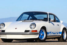 Classic whit Porsche Carrera parked on gravel
