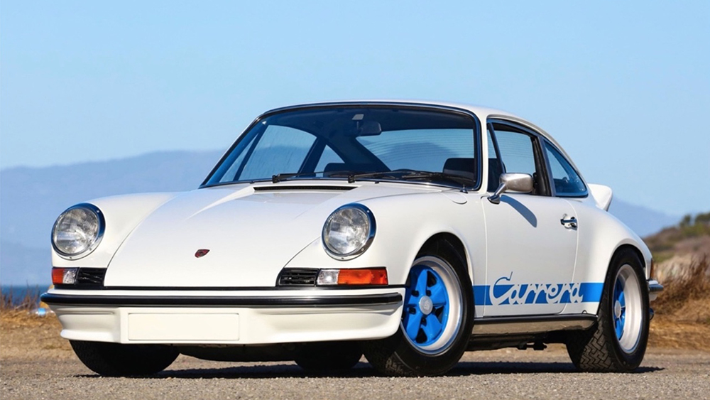 Classic whit Porsche Carrera parked on gravel