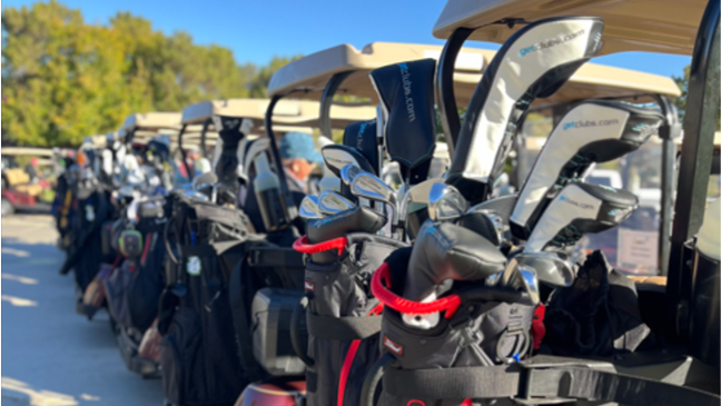 Golf glubs on back of row of golf carts