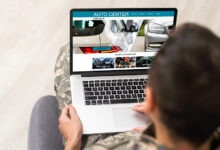 Person in chair buying car on laptop