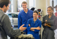 Mechanics discussing car engine in auto repair shop
