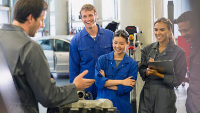 Mechanics discussing car engine in auto repair shop