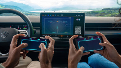 Two people using smartphones to play Breakout Recharged in a Volkswagen through AirConsole
