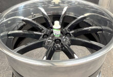 Aluminum wheel on floor with bottle sitting in center