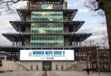 Women with Drive banner on front of building