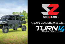 UTV parked in grass with Seizmik and Turn 14 Distribution logos