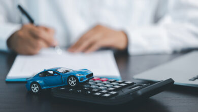 Blue Toy Car In Front Of Businessman Calculating Loan. Saving money for car concept, trade car for cash concept, finance concept.