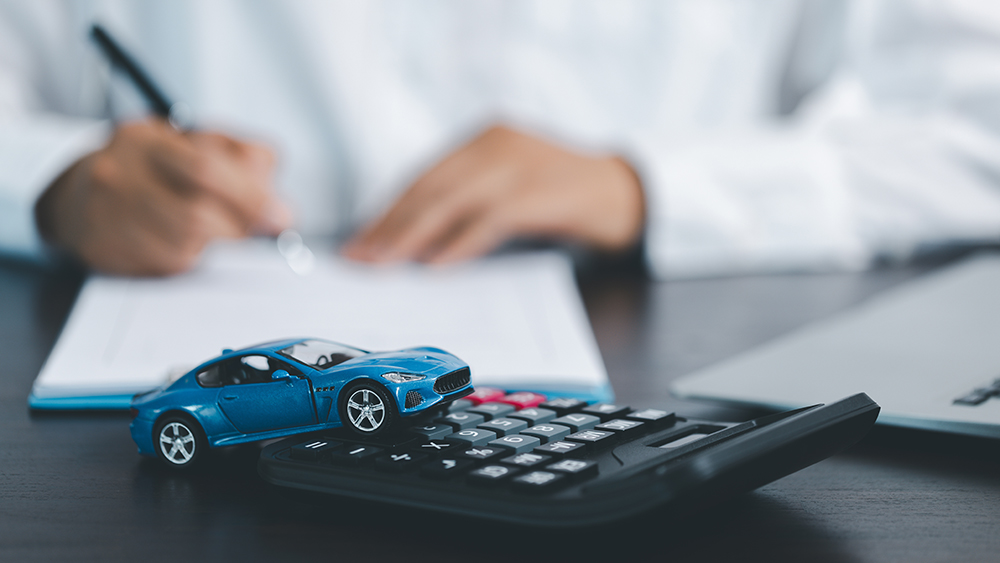 Blue Toy Car In Front Of Businessman Calculating Loan. Saving money for car concept, trade car for cash concept, finance concept.