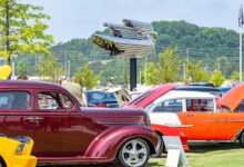 Classic cars with open hoods on the Savoy Automobile Museum grounds