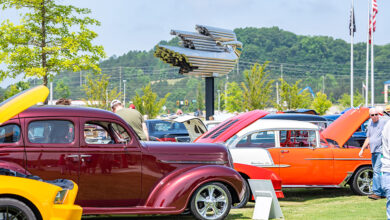 Classic cars with open hoods on the Savoy Automobile Museum grounds