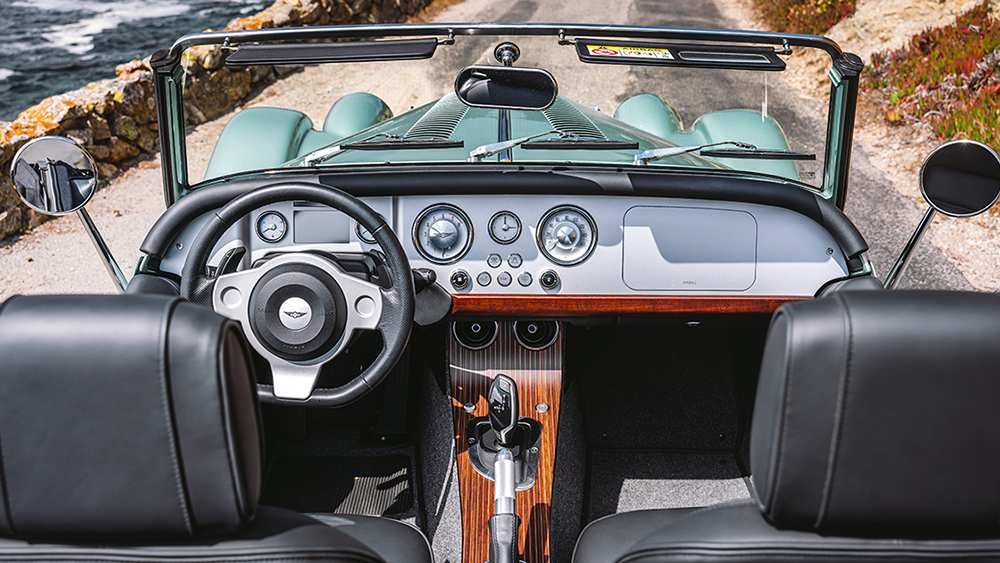Interior of Morgan Plus Four parked next to ocean