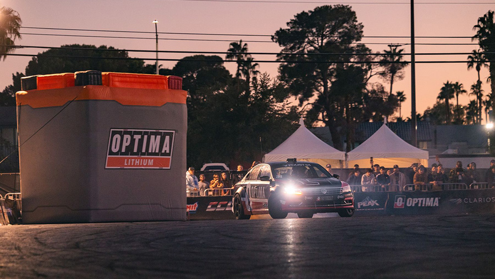 Optima Unleashed at night at SEMA Show with car and headlights