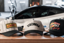 True Brvnd Pennzoil baseball caps sitting on table with car in background