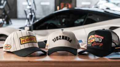 True Brvnd Pennzoil baseball caps sitting on table with car in background