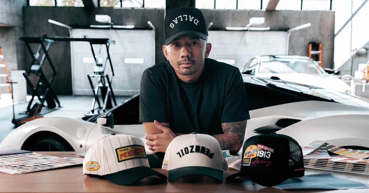 True Brvnd designer sitting at table with 3 Pennzoil baseball caps
