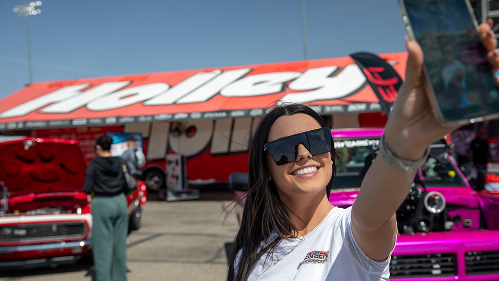 Influencer holding phone filming herself at Holley event