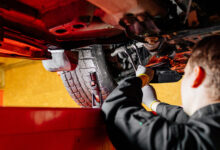 Car mechanic installing wheel alignment sensors, car suspension adjustment. Car mechanic at work