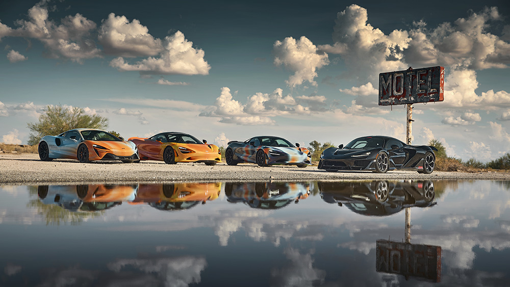 McLarens parked by water and old Motel sign