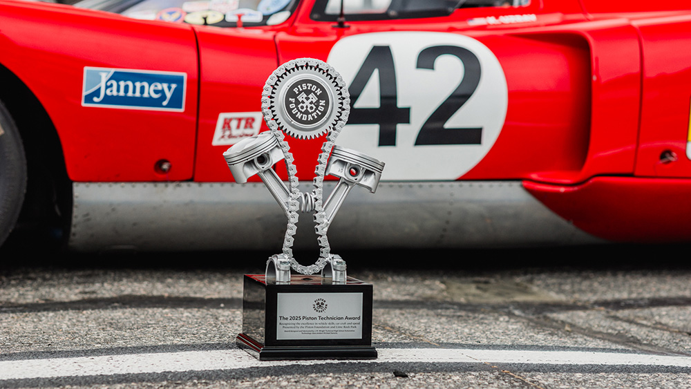 Piston Technician Award trophy on ground next to race car