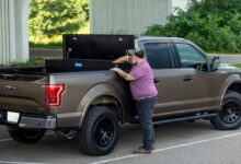 toolbox cargo man reaches into truck bed-mounted toolbox from lippert