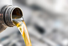 Pouring oil to car engine.
