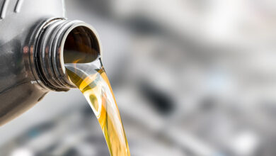 Pouring oil to car engine.