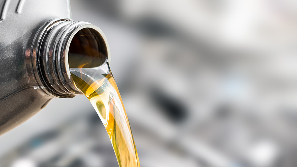 Pouring oil to car engine.