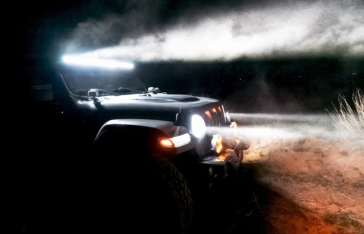 aftermarket lighting oracle lighting jeep with light bars at night on dusty trail