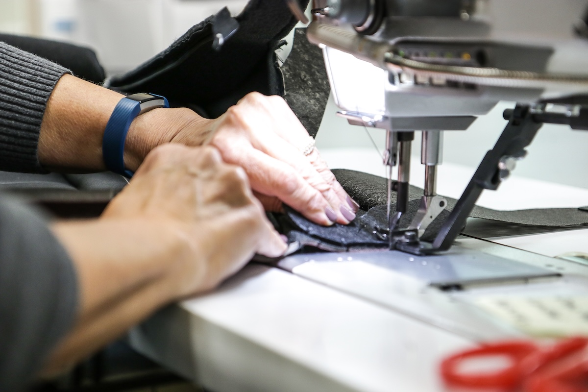 auto interior bridge of weir/piston interiors hands working sewing machine close-up