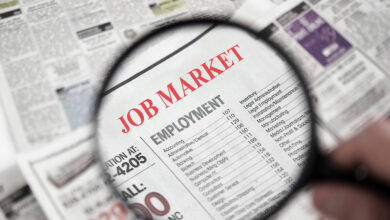 Magnifying glass over a newspaper classified section with Job Market text