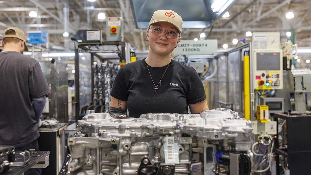 Tech looking at camera in Toyota hyprid production plant