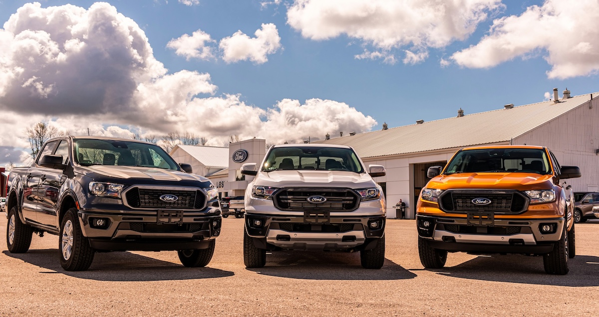 three ford trucks outside dealership