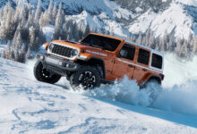2026 Jeep Wrangler Whitecap driving uphilll through snow