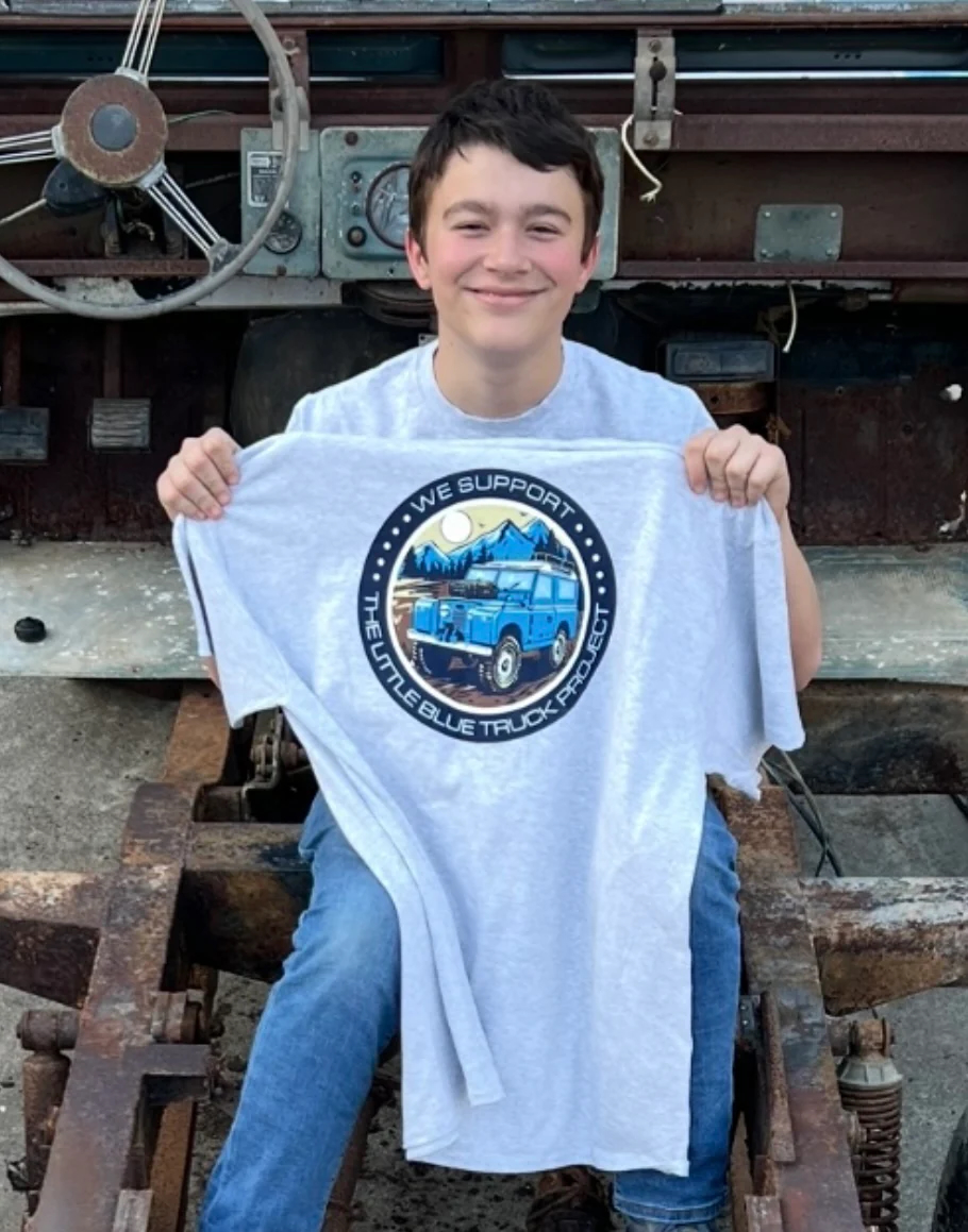 Victor holding T-Shirt while sitting in the 1963 Land Rover Series 2a