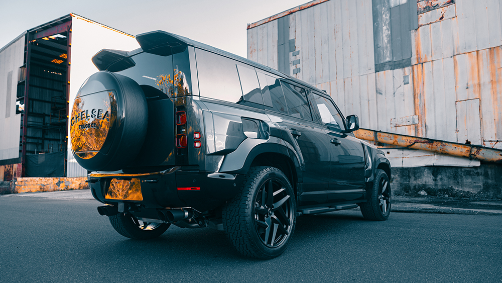 Defender 110 P525 V-8 in front of old building from rear