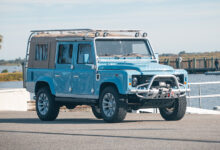 Light Blue Nautical Defender 110 parked at boat ramp