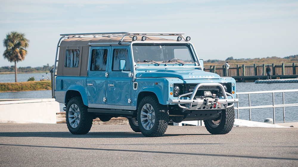 Light Blue Nautical Defender 110 parked at boat ramp
