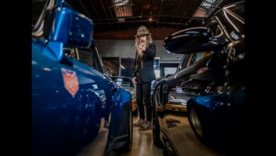 Magnus Walker pointing surrounded by Porsches