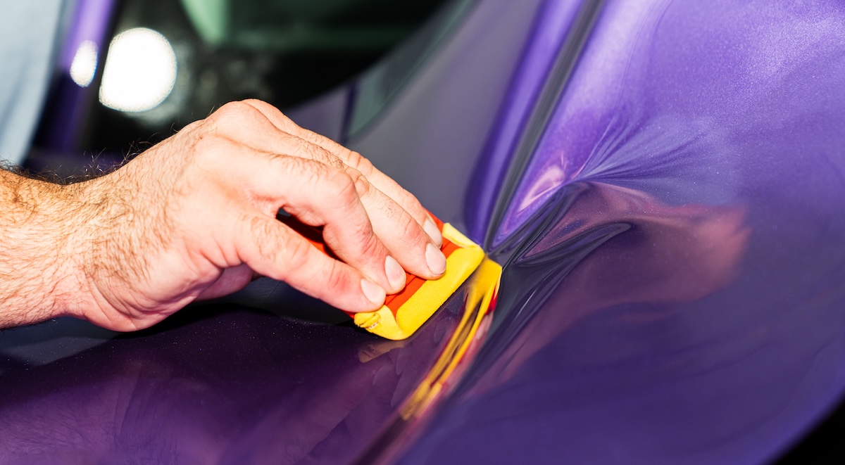 ppf avery dennison squeegee install closeup on purple film