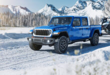 2026 Jeep Gladiator Whitecap hauling snow mobile in the snow