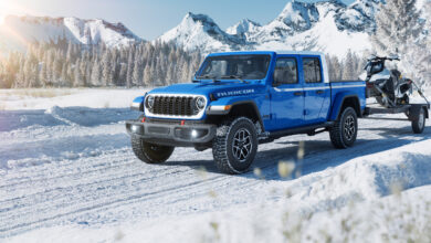 2026 Jeep Gladiator Whitecap hauling snow mobile in the snow
