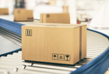 Cardboard boxes on conveyor rollers ready to be shipped by courier for distribution